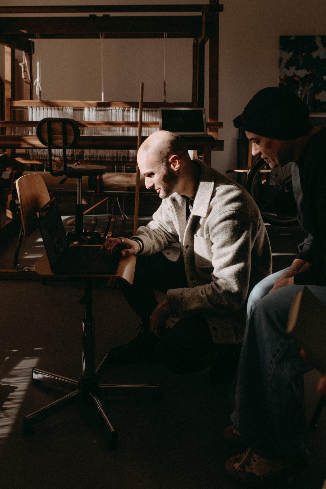 Travail de structuration mené dans l'atelier même de l'artisan, ordinateur devant le métier à tisser